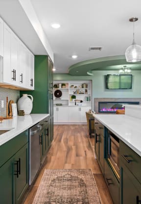 a large kitchen with green cabinets and white counter tops and a sink at Edgebrook Residences, Merrimack, 03054