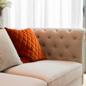 a couch with two pillows on it in a living room