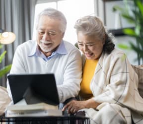 a man and woman looking at a laptop computer