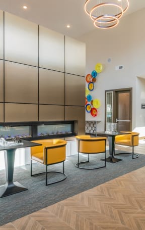 a kitchen and dining area with blue chairs and a colorful painting on the wall