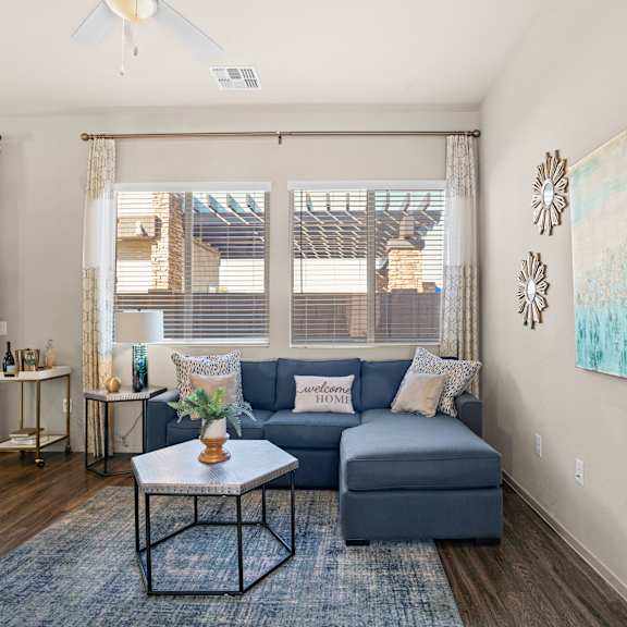 an open concept living room and dining area with a white dining table and rattan chairs