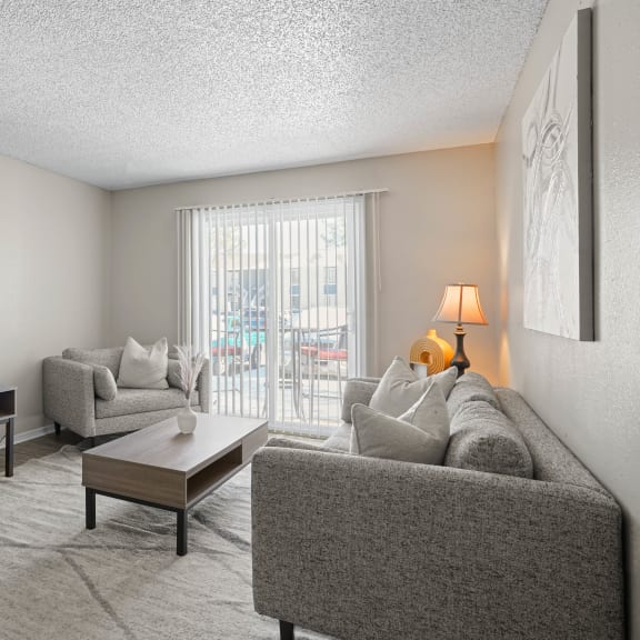 an open concept living room and dining area with a white dining table and rattan chairs