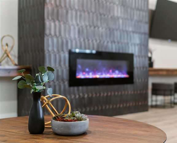 A modern living room with a fireplace and a flat screen TV mounted on the wall.