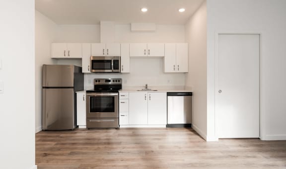 a kitchen with white cabinets and stainless steel appliances