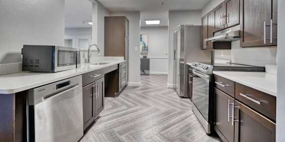 A kitchen with dark wood cabinets and stainless steel appliances.