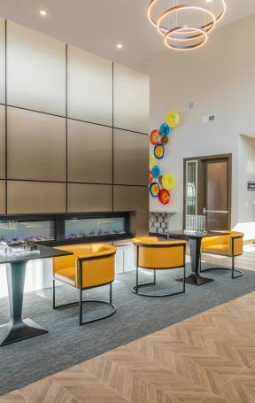 a kitchen and dining area with blue chairs and a colorful painting on the wall