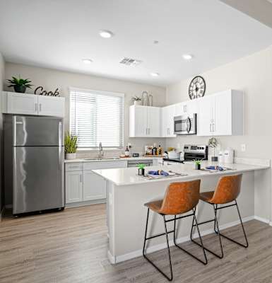 A modern kitchen with white cabinets and a stainless steel refrigerator.