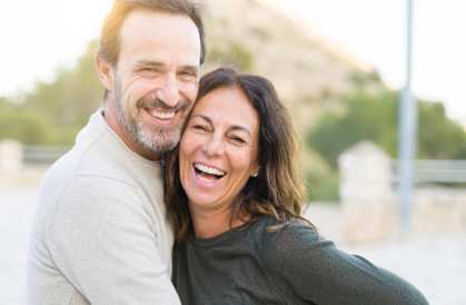 a man and a woman laughing with their arms around each other