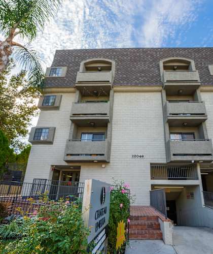 an apartment building with many balconies and a palm tree