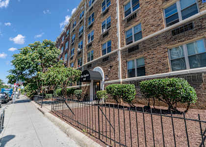 an apartment building with a gate and a sidewalk in front of it