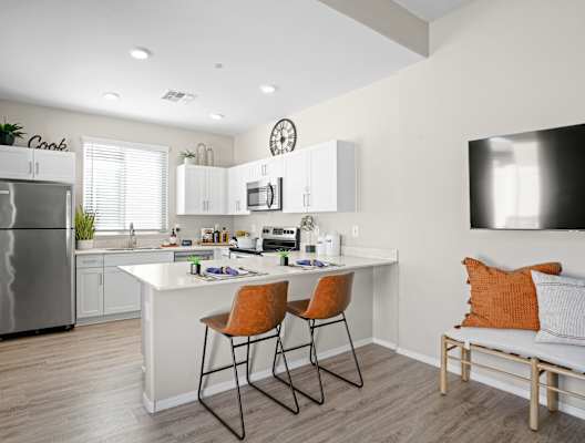 A modern kitchen with white cabinets and a stainless steel refrigerator.