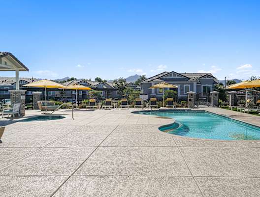 a swimming pool with patio furniture and umbrellas next to a resort style pool