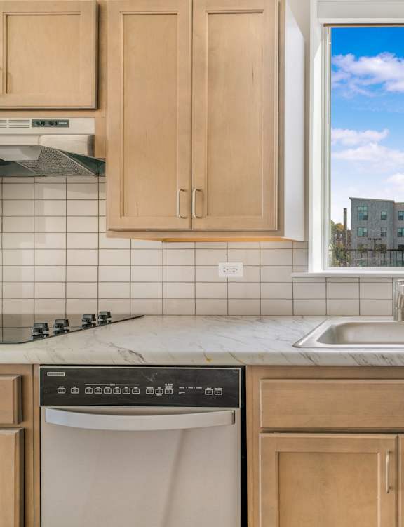 a kitchen with wooden cabinets and a window over the sink