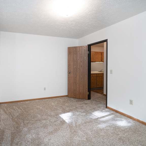 a white bedroom with a large bed and a window