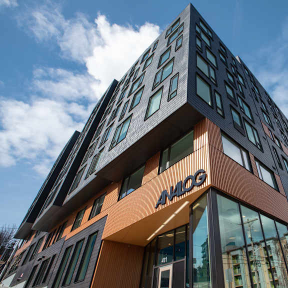 A modern building with a glass facade and a brown and orange exterior.