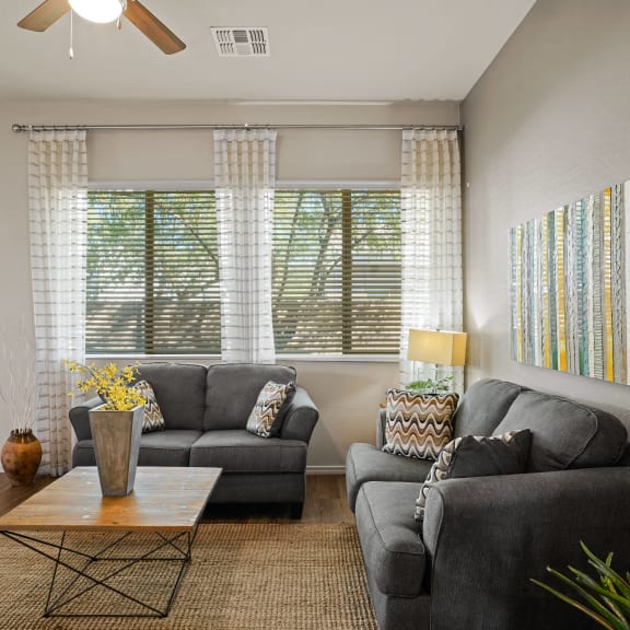 an open concept living room and dining area with a white dining table and rattan chairs