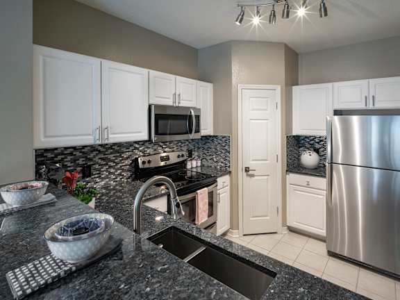 a kitchen with granite countertops and white cabinets