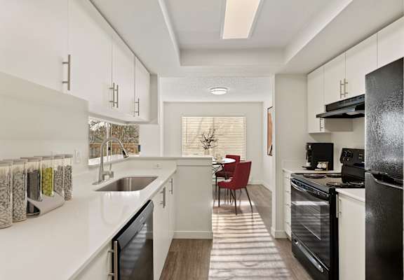 a kitchen with white cabinets and black appliances and a white counter top at Pointe East, Fife, Washington