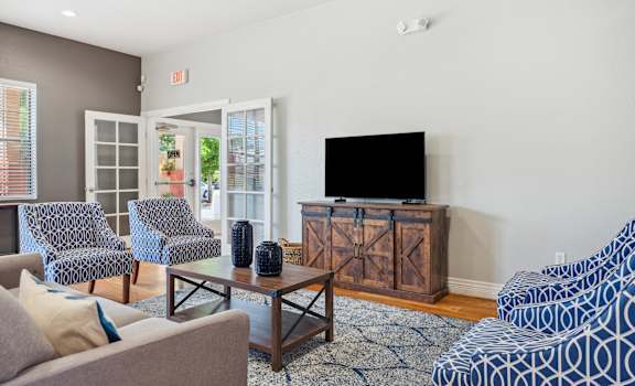a living room with a couch and chairs and a television