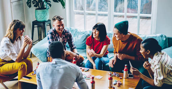 a group of people sitting around a table playing a board game