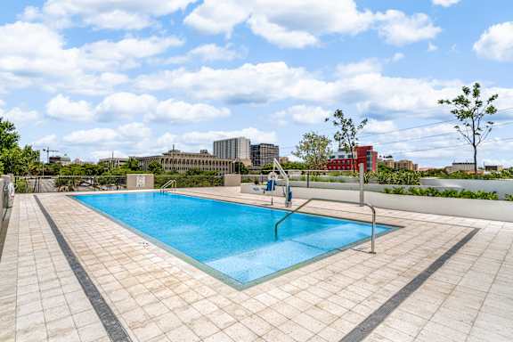 a swimming pool on the roof of a building with a city in the background