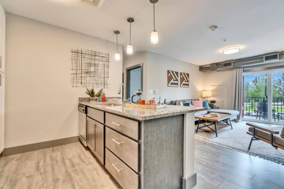 a kitchen with an island and a living room in the background
