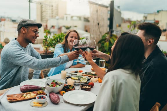 a group of people sitting around a table drinking wine