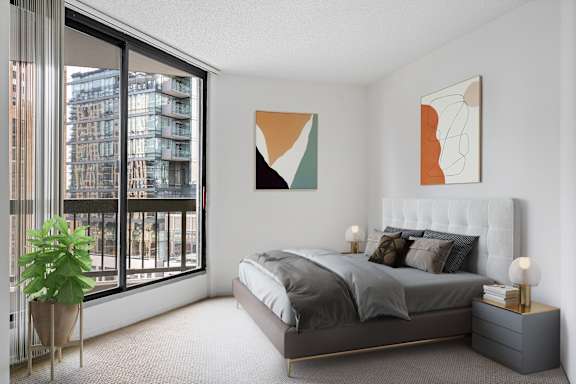 A bedroom with a large bed and a plant.