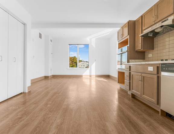 a kitchen with wooden floors and a window