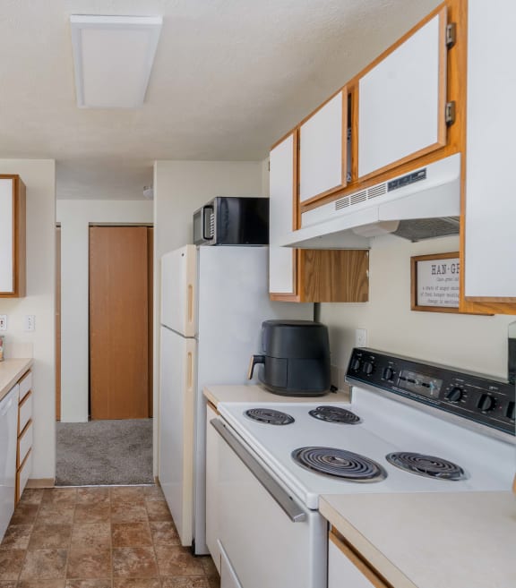 a kitchen with a white refrigerator freezer next to a white stove top oven  at Ironwood Apartments, Coeur d'Alene, 83814