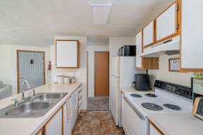 a kitchen with a white refrigerator freezer next to a white stove top oven at Ironwood Apartments, Coeur dAlene, ID, 83814