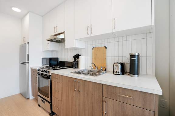 A modern kitchen with wooden cabinets and a white countertop.