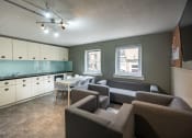 Thumbnail 4 of 8 - a living room and kitchen with couches and chairs and a table