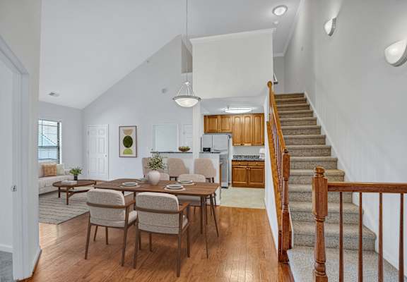 A dining room with a wooden table and chairs.
