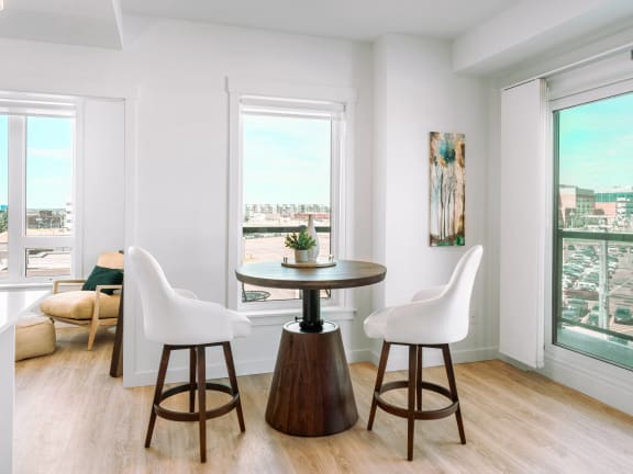 a living room with two chairs and a table and a window