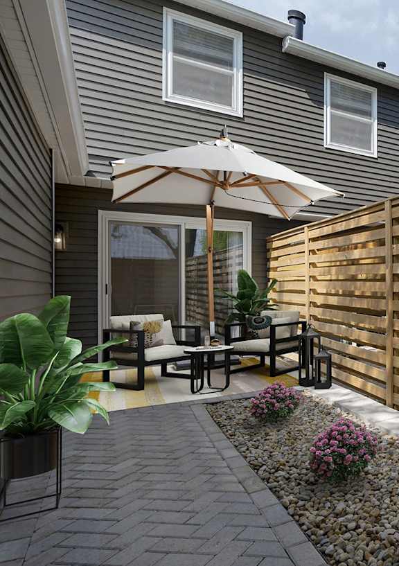 A patio with a table and chairs and a wooden fence.
