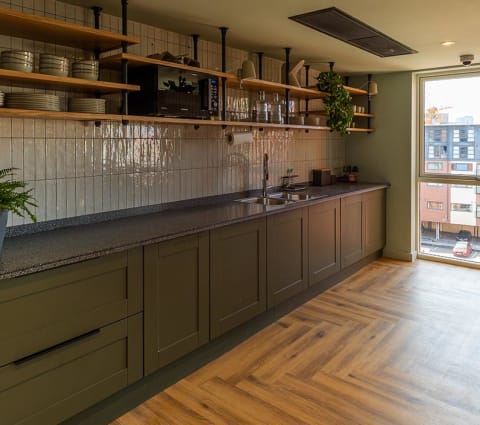 a kitchen with gray cabinets and a wood floor
