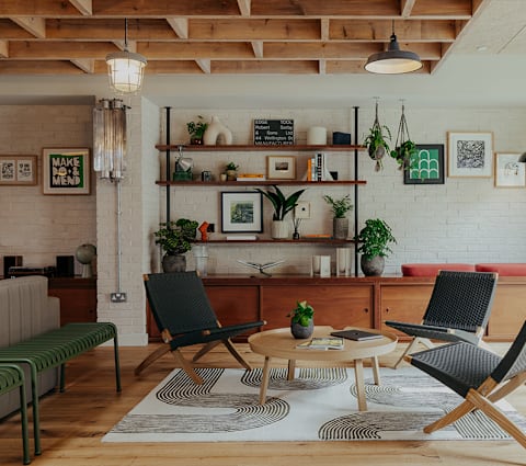 A living room with a green bench, a black chair, and a coffee table.