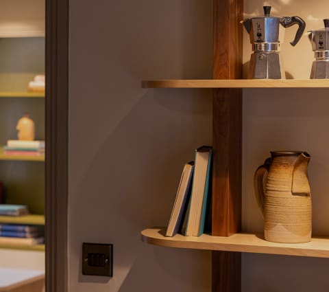 a shelf with books and a coffee maker on it