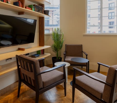 a living room with two chairs and a television