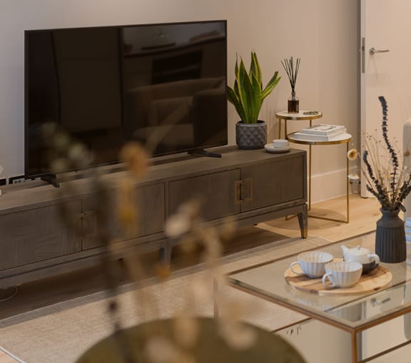 a living room with a couch and a coffee table with a vase