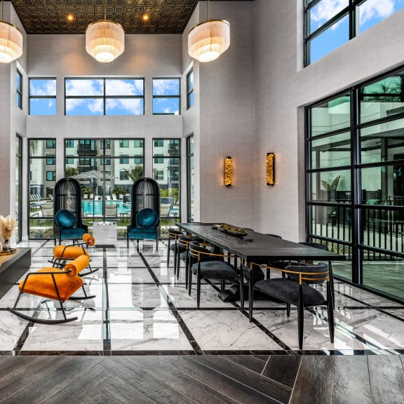 a large living room with large windows and a large table and chairs