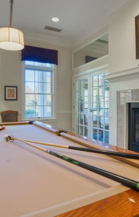 a pool table in a living room next to a fireplace