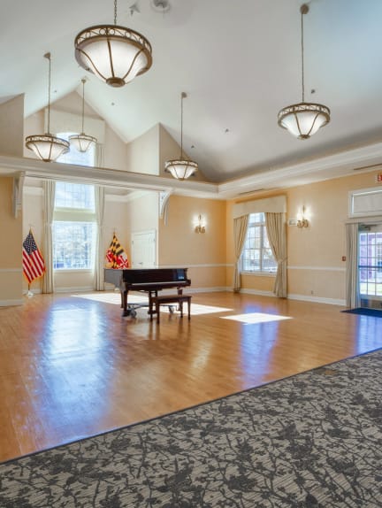 a large ballroom with a grand piano and a rug