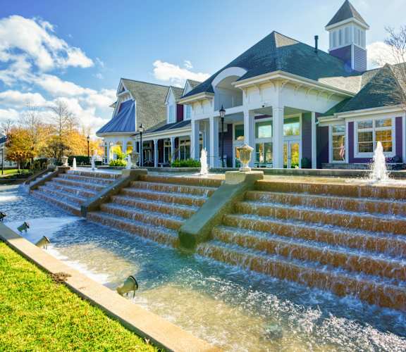 a large house with a fountain in front of it