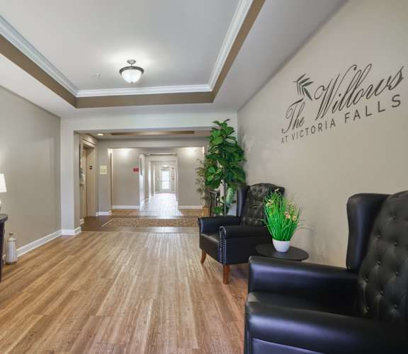 a hallway with leather chairs and a table with a plant