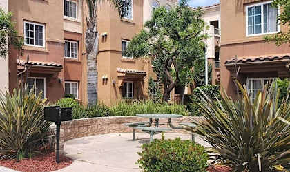 a picnic table in a courtyard in front of an apartment building