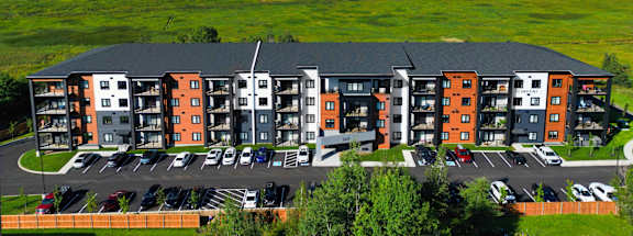 an aerial view of an apartment complex with a river in the background
