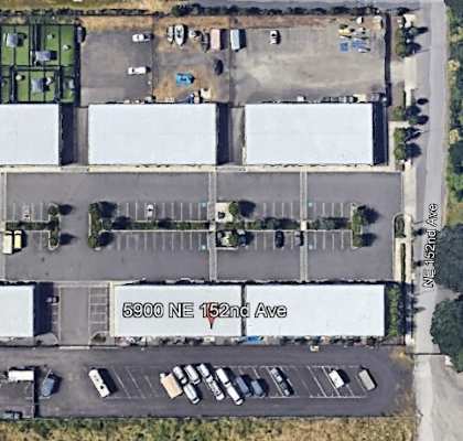 an aerial view of a parking lot with cars and buildings