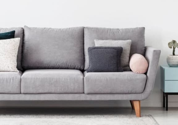 a grey couch with pillows in a living room